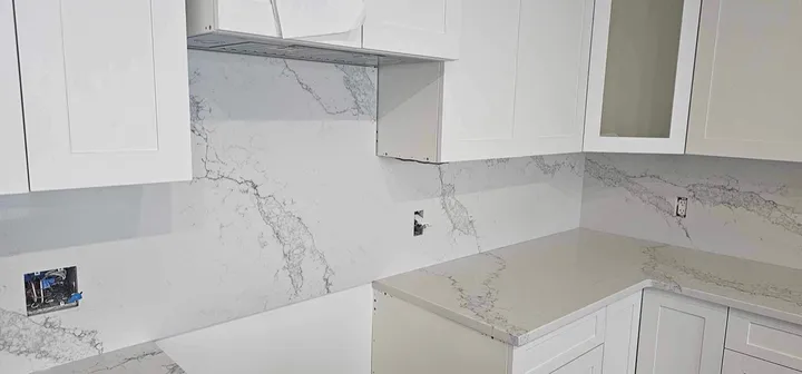 White kitchen with fine grey veined quartz counters and backsplash