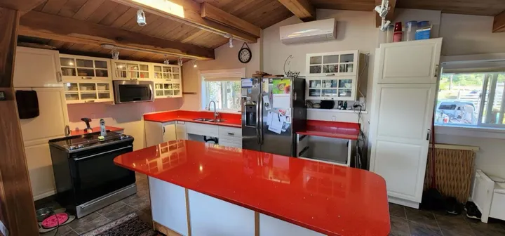 Polished red quartz island and matching kitchen counters