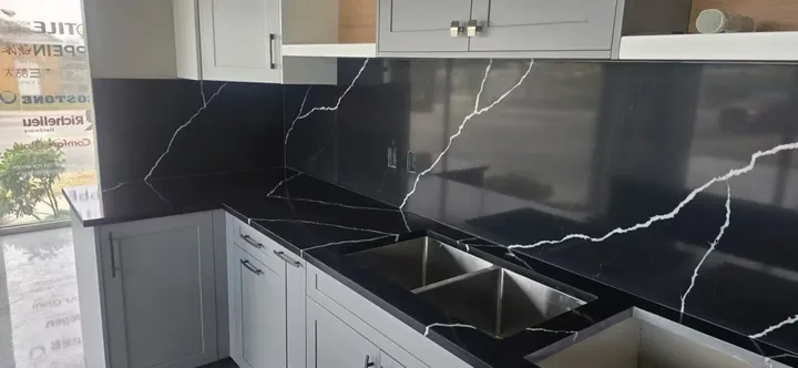 Black quartz counter and full-height white-veined backsplash