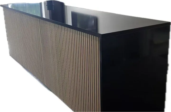 Polished black waterfall counter with a vertical wood-slat front